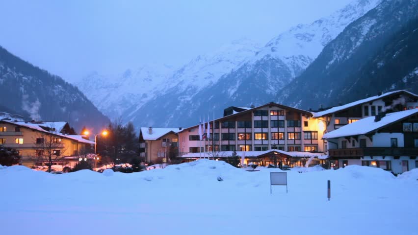 Hotels at ski resort village in mountains at winter evening