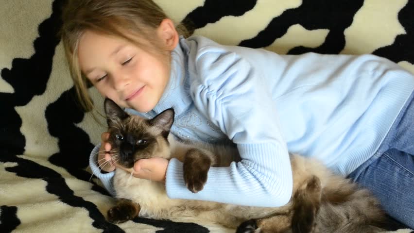 little girl gently hugs and stroking a kitten