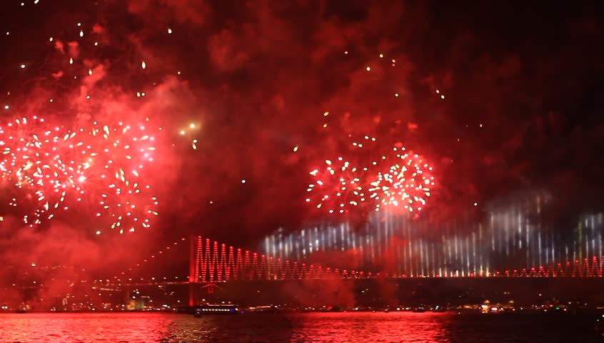 Fireworks all over the Istanbul sky View of Ortakoy region and Bosporus Bridge. Pan from Ciragan Palace to the bridge. 
