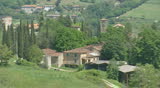 TUSCANY, ITALY - MAY 2009: Tuscan village on hillside with Cypress trees in Tuscan landscape (Cupressus sempervirens)
