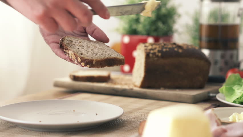 Woman spreading butter on slice of bread
