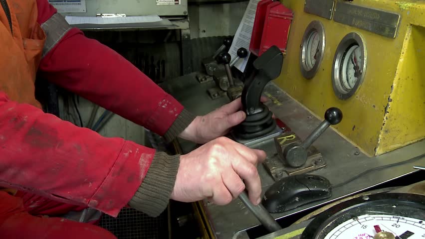 Worker controls drilling rig (hands)