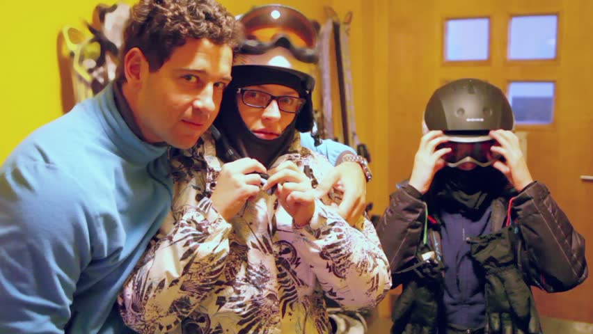 Husband kisses his wife then family prepares to ride ski
