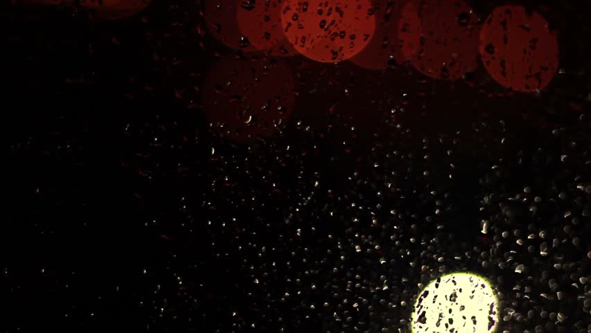 Raindrops on glass window at night
