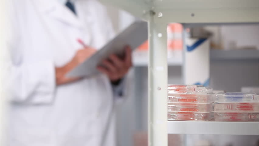 Pharmacist looking at pills in a shelf in a hospital