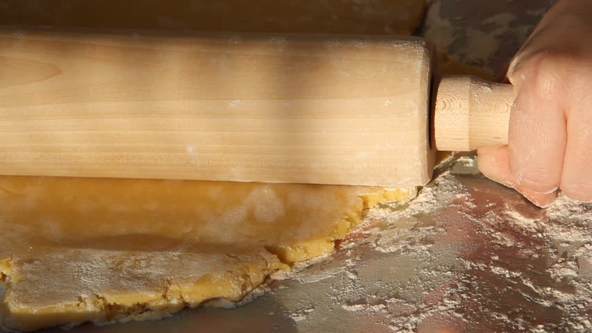 Baking Sugar Cookies 10. Preparing, mixing, baking and decorating Christmas sugar cookies. Flattening cookie dough with a rolling pin.