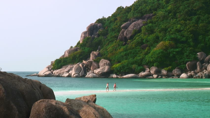 NANG YUAN, KOH TAO, THAILAND, DECEMBER 17: Tourists walking across a tropical beach sandbar December 17, 2008 in Nang Yuan, Koh Tao, Thailand. 
