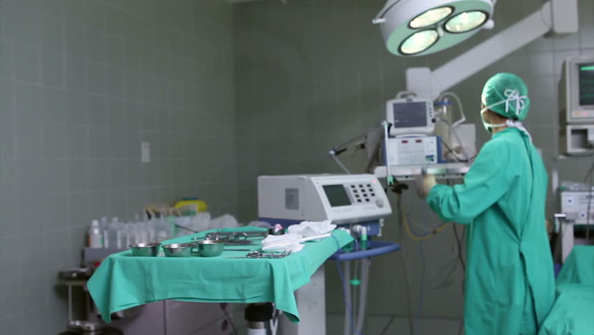 Nurse tying the mask of the doctor in hospital ward