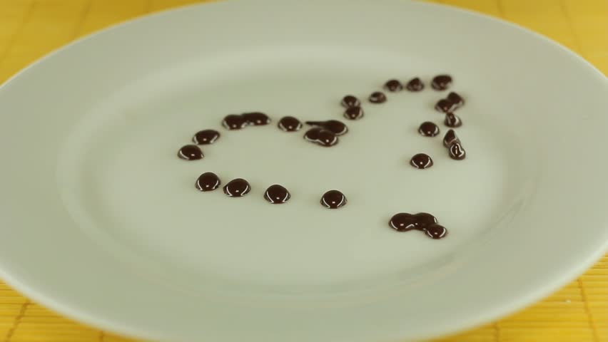 A cook draws a chocolate heart