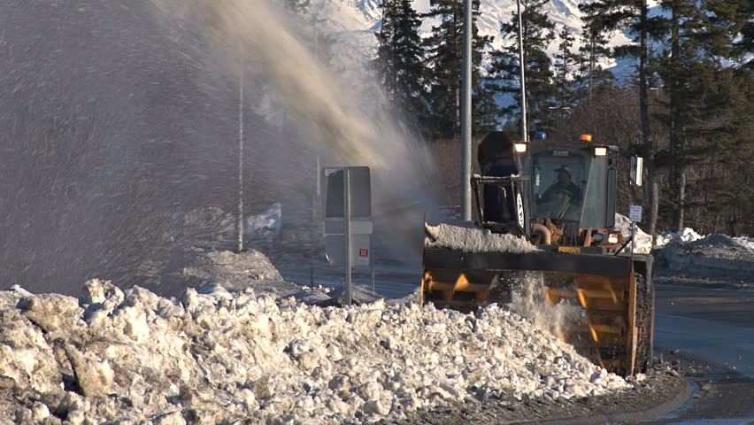 HOMER, AK - CIRCA 2012: This snow blower is clearing the sidewalk next to the Homer Bypass/Sterling Highway.