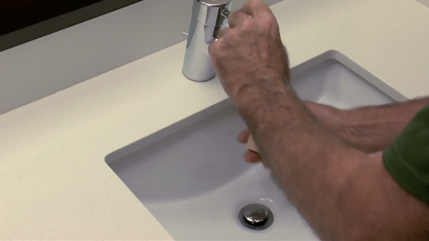 Man uses soap to lather, wash hands, over bathroom sink. 1080p
