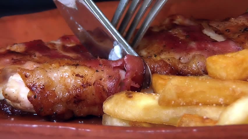 Eating meat and french fries 
