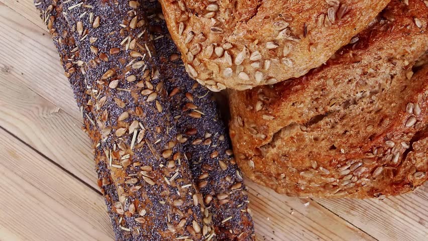 delicacy french rye breads and baguettes topped with sunflower and poppy seeds over wooden table