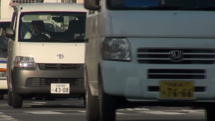 KYOTO, JAPAN - 26 OCTOBER 2012: Low shot of cars, vans, and other traffic going through a main street in downtown Kyoto, Japan