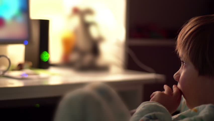 Sony FS-100 - Young boy picking his nose while watching cartoons in a dark room on a computer.