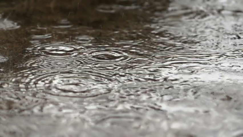 Rain drops dripping in a puddle - slow motion
