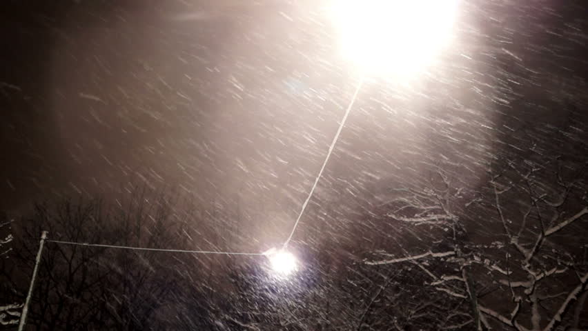 Falling snow at night, shot against street lamp