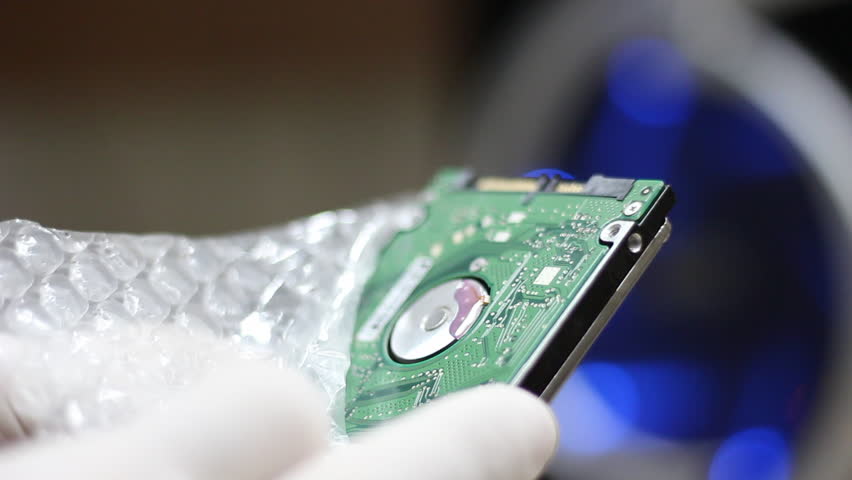 Technician wrapping hard drives for shipment    