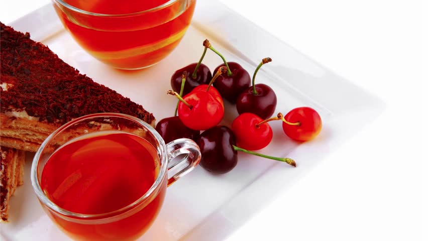 english cake and tea with cherry on white plate