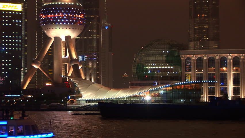 Lit up boat passes Pudong, Shanghai, China, River Huangpu, skyline at night, zoom out