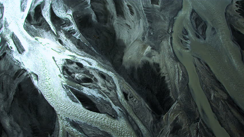 Aerial view of glacial meltwaters and volcanic ash in river deltas carving through flood plains, arctic region, Northern Hemisphere