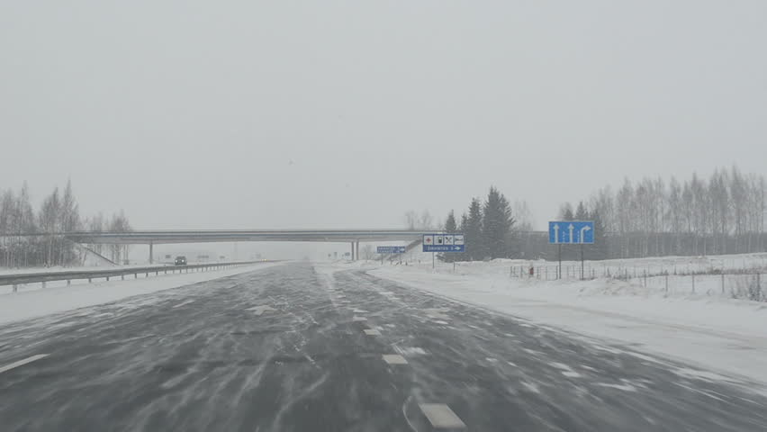 dangerous driving on highway. snow falling dense blizzard. car front window view in winter.
