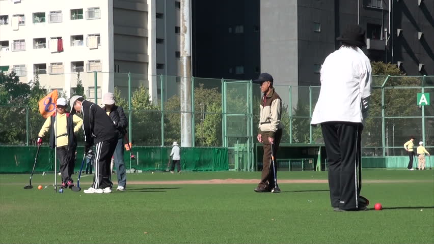 TOKYO, JAPAN - 5 NOVEMBER 2012: Pensioners are playing gateball in a park in Tokyo, Japan Gateball was invented in Japan by Suzuki Kazunobu in 1947. At the time there was a severe shortage of rubber needed to make the balls used in many sports.