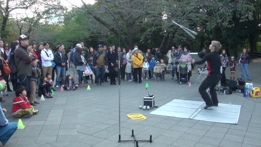 TOKYO, JAPAN - 3 NOVEMBER 2012: Performance of a young man doing gymnastics and tricks in Ueno park in Tokyo, Japan