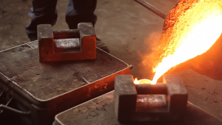 Liquid metal in the factory, foundry, smelting iron and processing, workers pouring liquid iron into molds. Iron casting