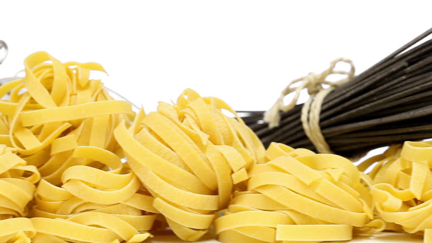 Collection from mixed uncooked raw pasta - spaghetti, farfalle, tagliatelle and black spaghetti