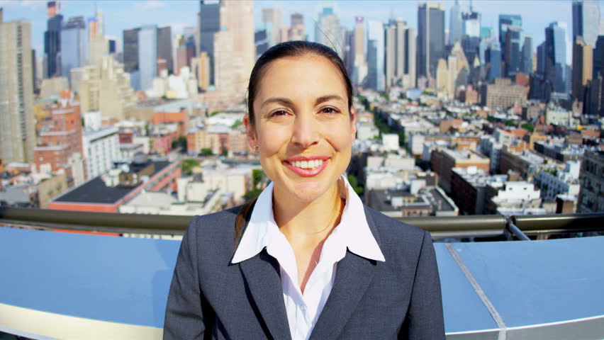 Portrait of Caucasian attractive businesswoman celebrating success on rooftop overlooking Manhattan