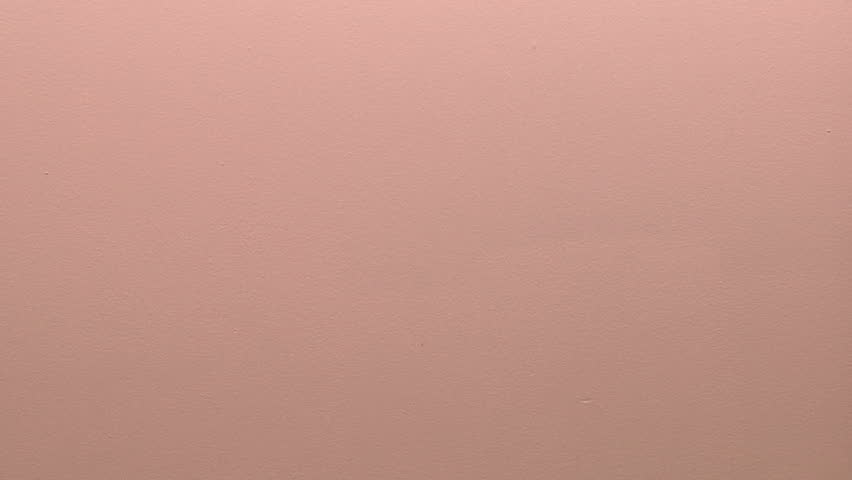 time lapse of a painter rolling red paint onto a white wall