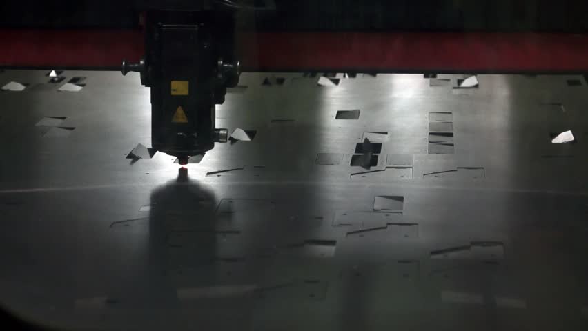 Industrial automated machinery cutting a metal board