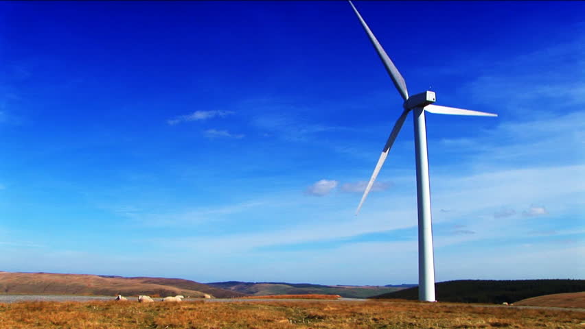 single wind turbine on hill blue sky