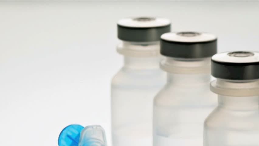 Medical drug vials and syringe against white background