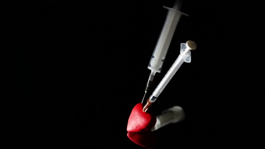 Two different syringe stuck in the red heart