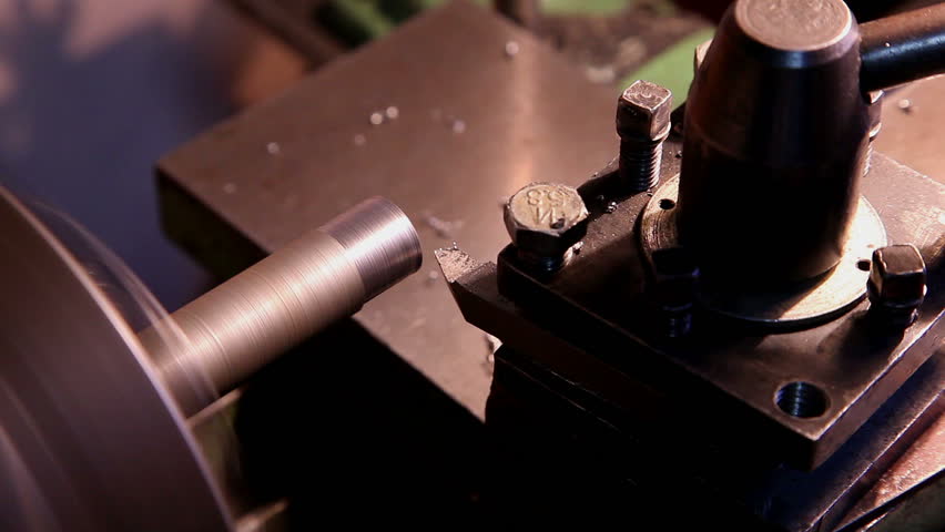 worker handles metal piece on the lathe 4