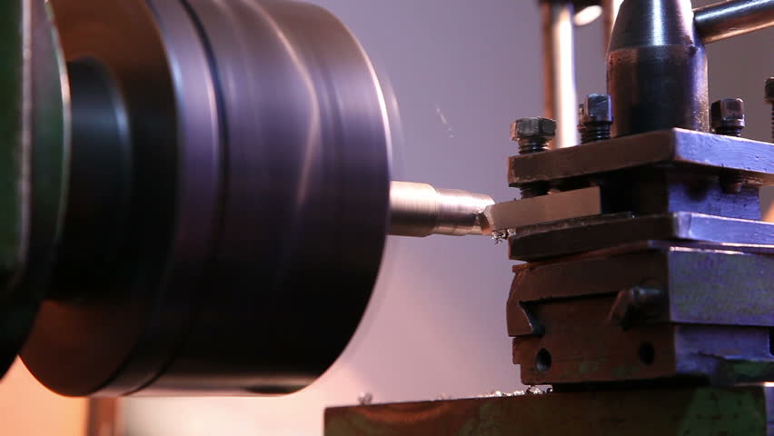 worker handles metal piece on the lathe 1