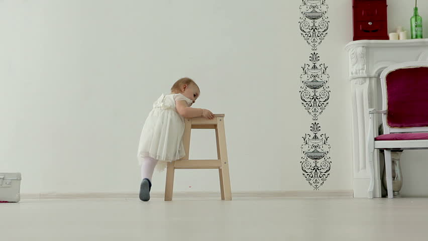 Little girl climbs on a step ladder and claps