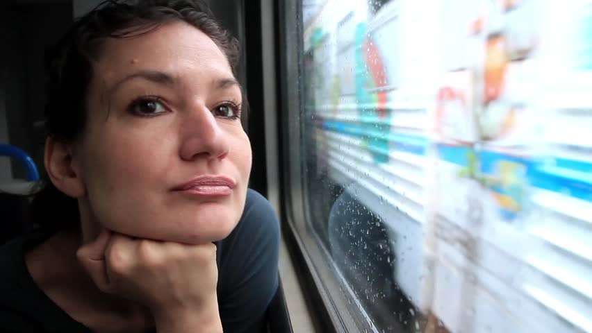 Woman sits in train near window during movement