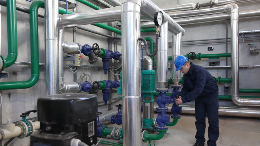 Man working in a factory, controls the operation of devices in a Heating Plant