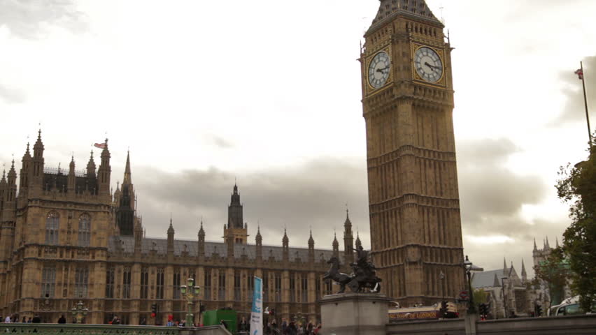 Big ben and Westminster Abbey with cloudy sky in background in London, England.