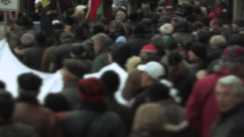 Protesters in Eastern Europe hold a flag.