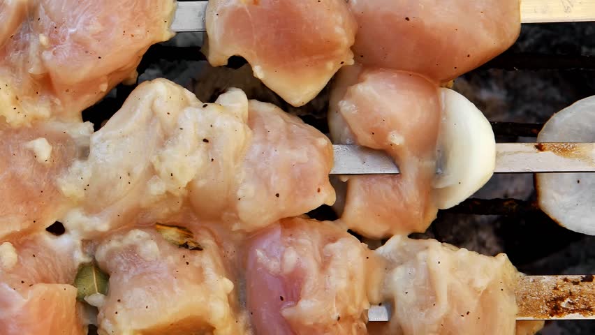 grilled and raw chicken shish kebab cooked on barbecue appliance