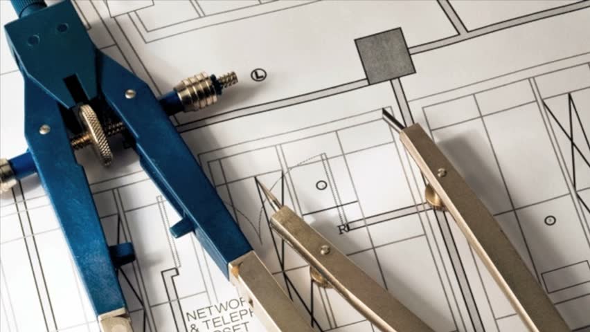 Drafting compass and dividers against a blueprint