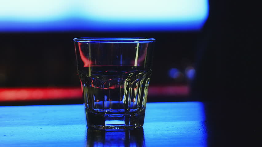 Drinking in the bar, dark depressed atmosphere and glass for a lonely drinker.
