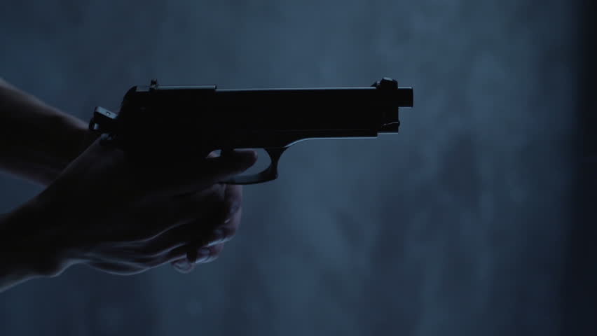 Man with 9 mm handgun takes a shot. Shot from above with an angle