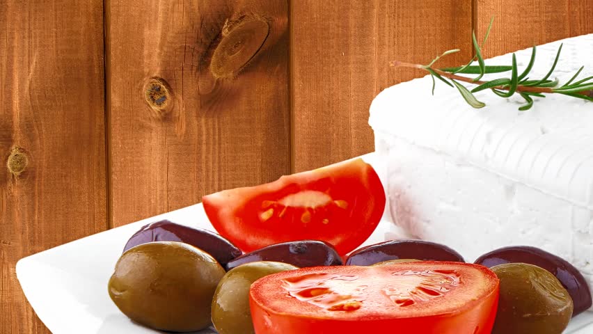 feta cube and olive over white plate with bread