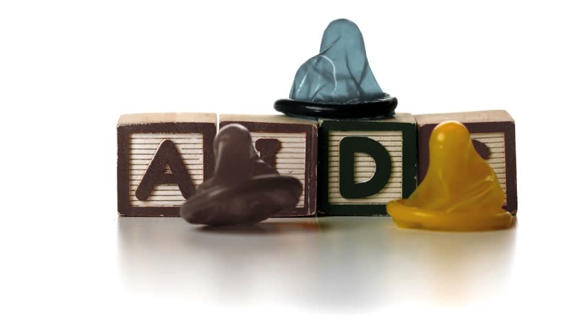 Three condoms falling on blocks spelling AIDS in slow motion