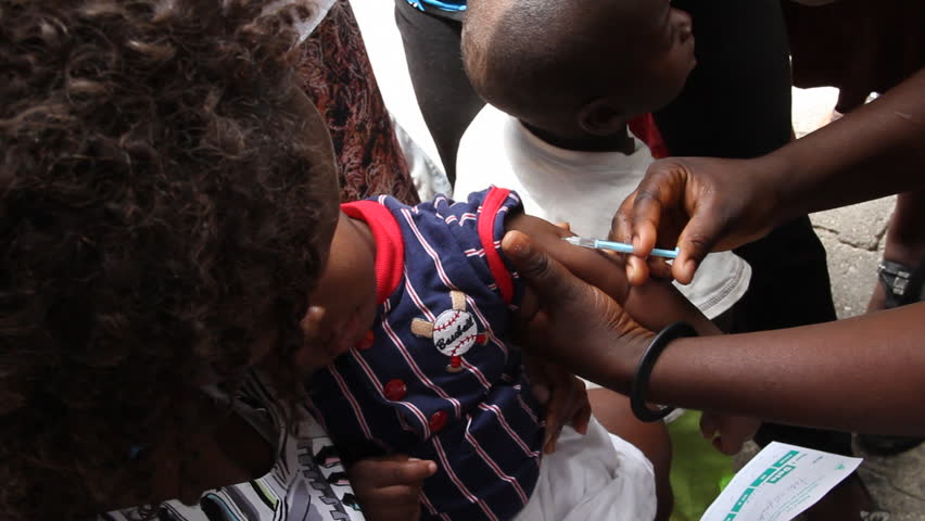 HAITI - CIRCA MAY 2012: young Haitian child receives vaccine shot in a Port Au Prince clinic 